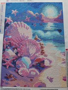 the cross stitch pattern is in progress to make it look like they are on the beach