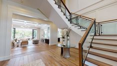 a staircase in a house with wood floors and glass balconies