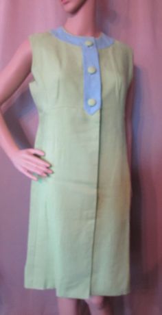 "LAST CALL! 50% OFF! Offered is an attractive vintage summer dress that is as fashionable today as it was decades ago. It is a sleeveless sheath in color block combination of lime green and sky blue. The blue plays at the banded neckline forming a front placket with large lime fabric buttons. Below the waist the lime green dress closes with 2 large hidden snaps. This has an empire waistline. The cut is generally a princess cut with a front pleat panel for the skirt. The back is equally handsome Green Sleeveless Retro Vintage Dress, Sleeveless Blue Dress For Vintage Fashion, 1950s Blue Summer Dress, 1950s Style Blue Summer Dress, Blue 1950s Style Summer Dress, Green Summer Dresses In Vintage Style, Blue Lined Vintage Dress For Summer, Green Summer Dresses For Vintage Fashion, Green Summer Dress For Vintage Fashion