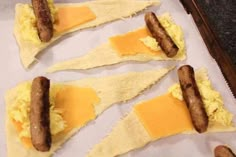 sausages and eggs are on top of tortilla shells with cheese in them