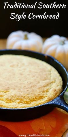 a skillet filled with cornbread sitting on top of an orange cloth next to white pumpkins