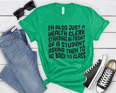 Premium School Health Clerk Shirt. This humorous t-shirt for school health aides is bound to brighten your day! A perfect graphic tee designed for health assistants. Treat yourself or delight a health clerk with this playful gift! Sizing: - Runs true to retail size, but some people might prefer to size up or down - Please check the size chart added to the pictures - Unisex design is comfortable and flattering for both men and women - Fit style is retail fit* *I would describe this fit as a more Funny Text Relaxed Fit T-shirt For School, Green Text Print T-shirt For School, Green T-shirt For School, Green Relaxed Fit T-shirt For School, Back To School Shirts, Unisex Looks, Health Humor, School Health, Graphic Tee Design