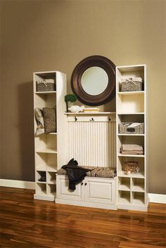 a white bookcase with an oval mirror above it