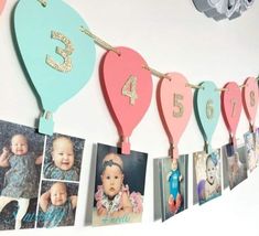 a bunch of pictures hanging on a wall with numbers and balloons attached to the strings