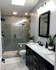 a bathroom with two sinks, a toilet and a shower