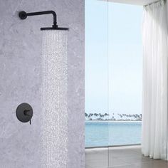 an open shower head with water running from it and a large window in the background