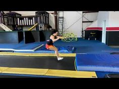 a woman is jumping on a trampoline course