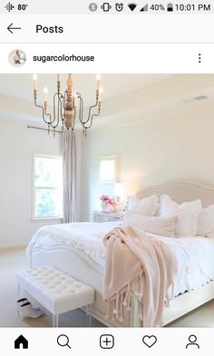 a bedroom with a white bed and chandelier hanging from it's ceiling