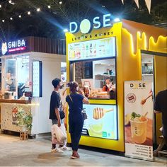 people are standing in front of a food stand