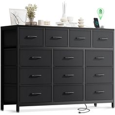 a large black dresser with many drawers on it's sides and an electronic device sitting on top of it