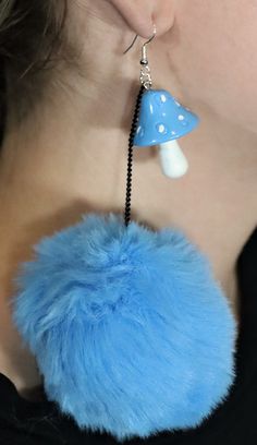 a close up of a person wearing earring with a blue object on it's ear