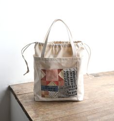 a bag sitting on top of a wooden table next to a white wall and floor