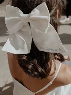 a woman wearing a white dress with a large bow on her head and the words not going to be written on it