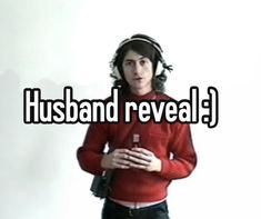 a man with headphones on standing in front of a white background that says husband reveal