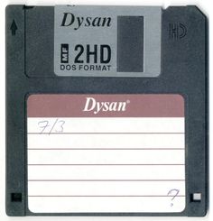 a floppy disk with a name tag attached to the front and back of it that says dysan