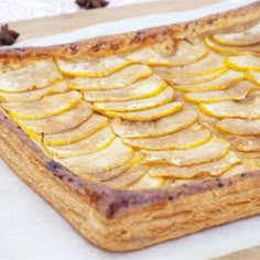 an apple tart sitting on top of a wooden cutting board