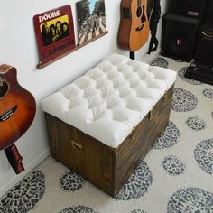 a room with guitars on the wall, and a bench in front of an acoustic guitar