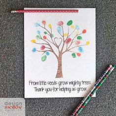 a card with a tree on it next to two crayons and pencils