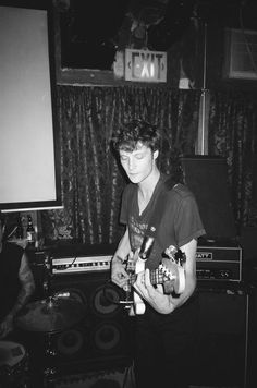 a young man playing an electric guitar in a recording studio