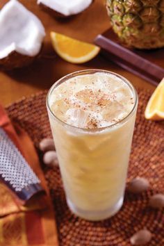 a pineapple drink is garnished with cinnamon and sugar on a table next to other fruit