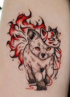 a tattoo with an image of a fox and a cat on it's thigh