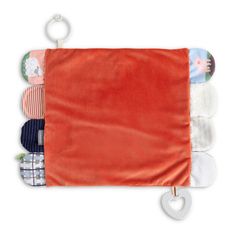 an orange towel hanging from a metal hook on a white background with several different items in it