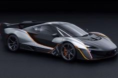 an orange and black sports car on a dark background