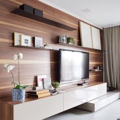 a living room with a large flat screen tv on top of a white entertainment center