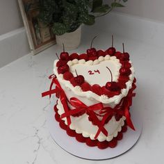 a heart shaped cake with red ribbon on top