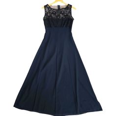 a blue dress with black lace on the top and bottom, sitting on a hanger