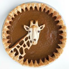 a pie with a giraffe's head on it is shown in the middle