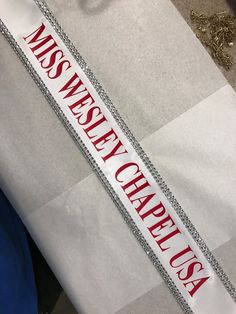 a white and red sash with the words miss west chapel usa on it's side