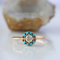 a close up of a ring with a stone in the middle and a rock in the background