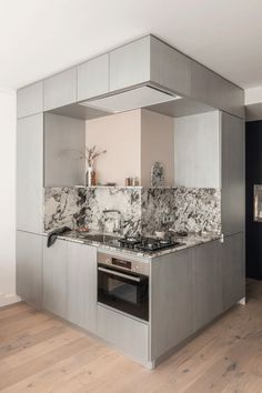 a modern kitchen with stainless steel appliances and marble counter tops, along with hardwood flooring