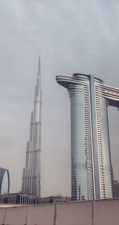 two tall buildings in front of a cloudy sky