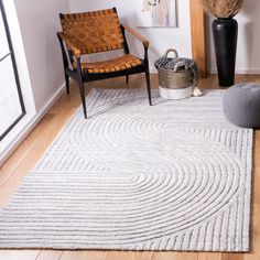 a room with a chair, rug and pictures on the wall