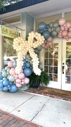 balloons are on display in front of a storefront with the letters k and m above them