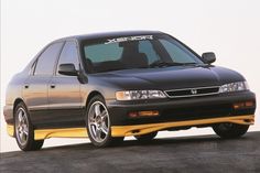 the front end of a black and yellow honda accord