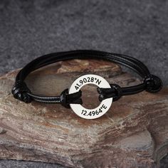 a black leather bracelet with two silver circles on it and the words, am09n