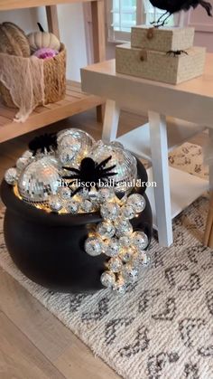 a black bird sitting on top of a table next to a bowl filled with crystal balls