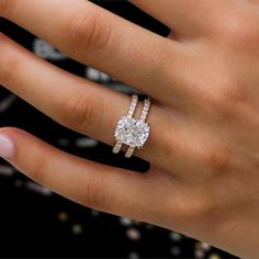 a woman's hand with a diamond ring on top of her finger and an engagement band