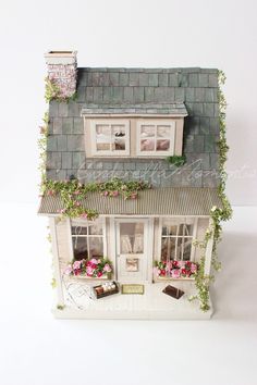 a doll house with flowers on the windows