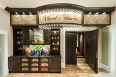 the wood theatre bar has many bottles and glasses on it's display shelves, along with an assortment of drinks