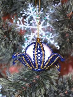 a blue and gold ornament hanging from a christmas tree