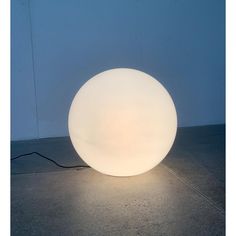 a large white ball lamp sitting on top of a floor