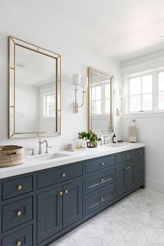 a bathroom with two sinks and large mirrors on the wall next to eachother