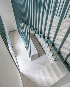 the stairs are made of glass and have blue railings on each side, along with marble steps