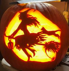 a carved pumpkin with an image of witches on it