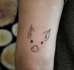 a small pig tattoo on the arm