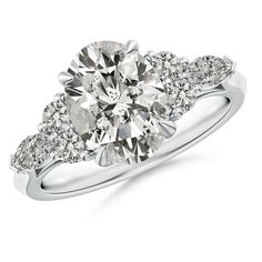 a three stone engagement ring with diamonds on the sides and an oval shaped diamond in the center